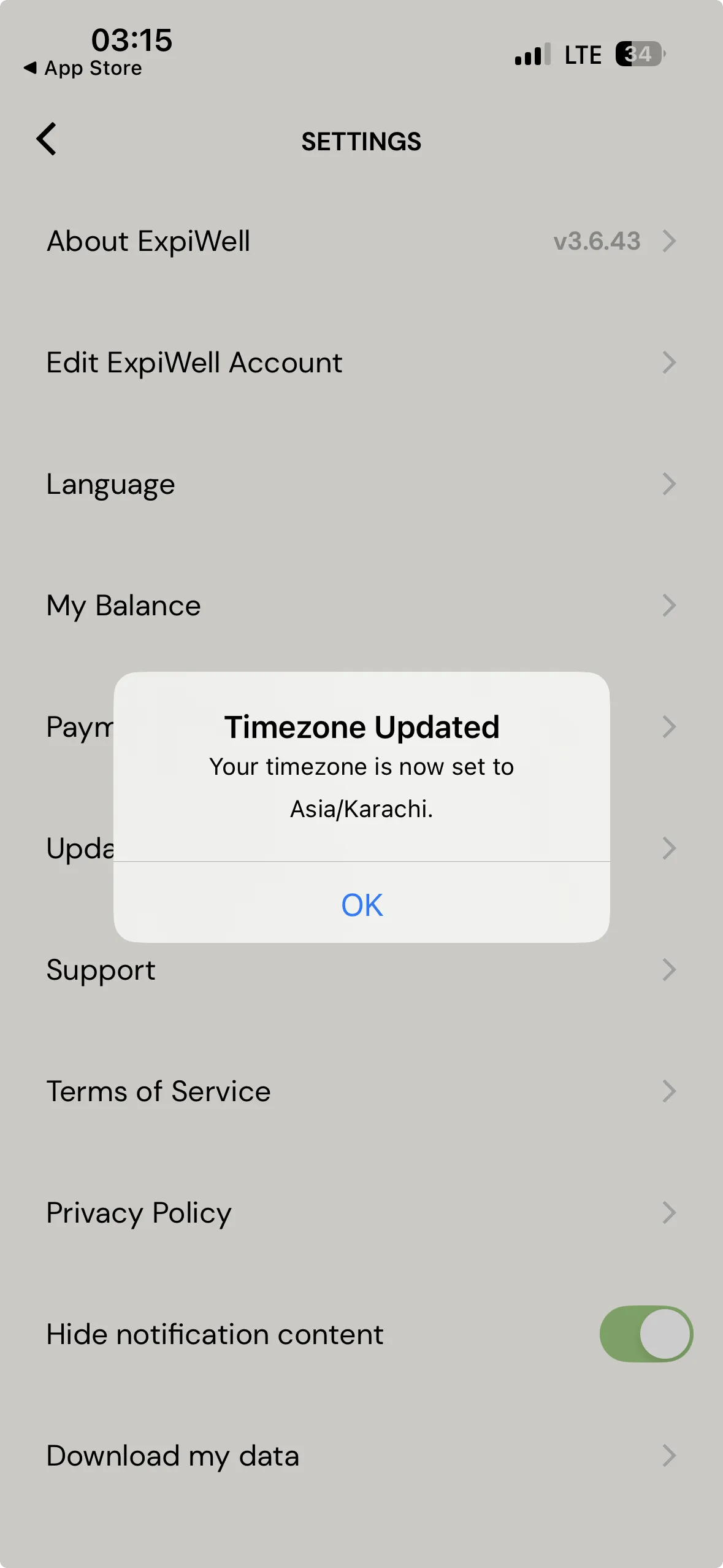 The ExpiWell mobile app Settings screen with a dialog over it headed Timezone Updated, reading that the participant's timezone is now set to Asia slash Karachi, with an OK button